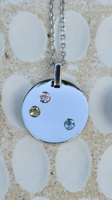 Sterling silver disc pendant with natural gemstones to empower wearers to embrace change